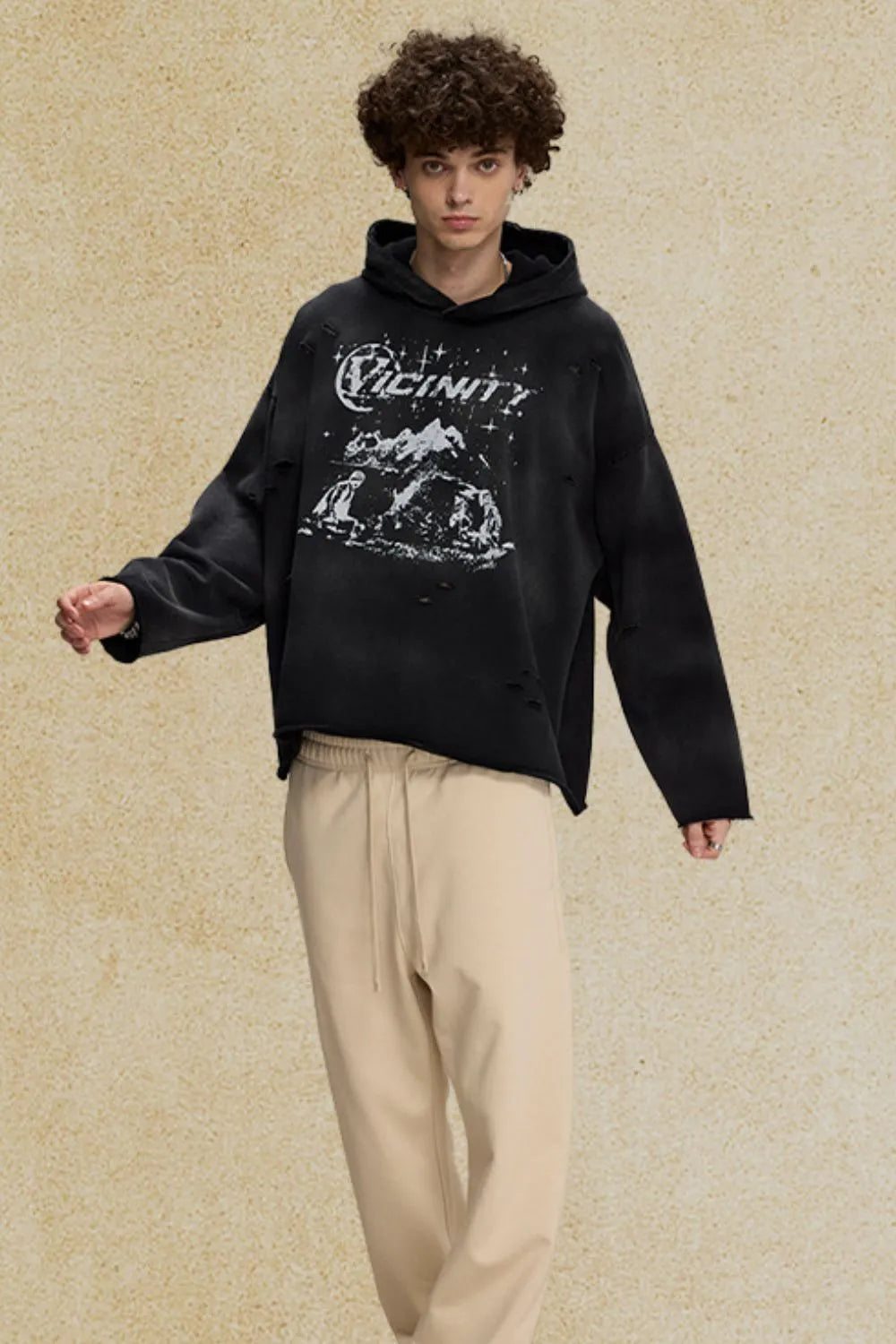 Black oversized distressed graphic hoodie with distressed details and a crew neckline.