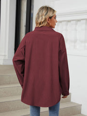 Oversized corduroy shirt jacket in burgundy with buttoned cuffs and a relaxed fit.