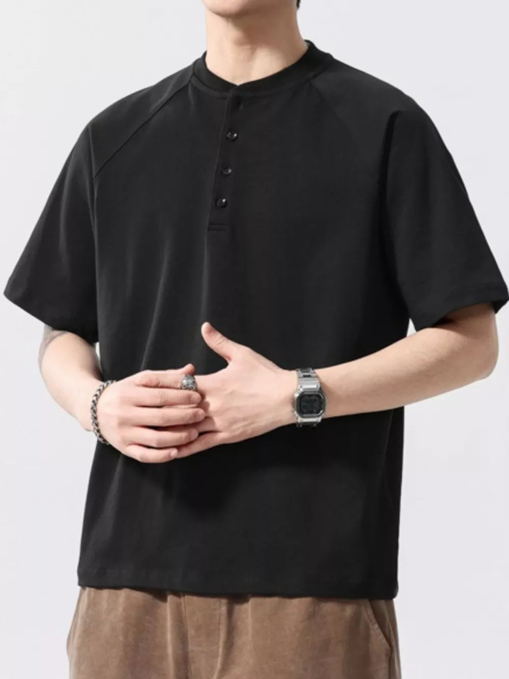 Black buttoned henley t-shirt for men with short sleeves and a crew neck.