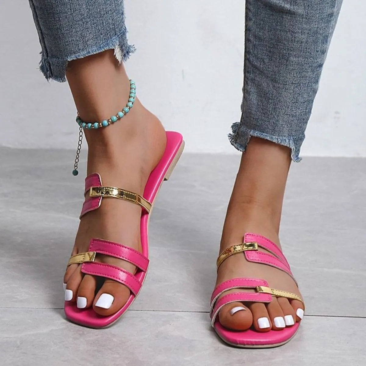 Hot pink flat slides with metallic gold accent straps and a square toe.