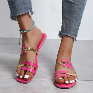Hot pink flat slides with metallic gold accent straps and a square toe.
