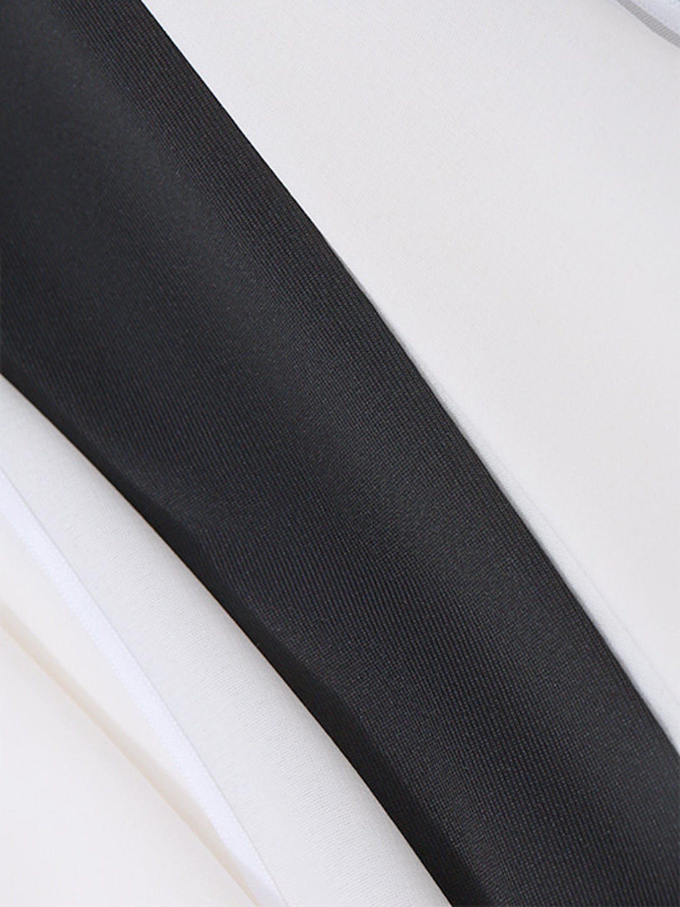 Black and white fabric detail of a dress with a bowknot accent