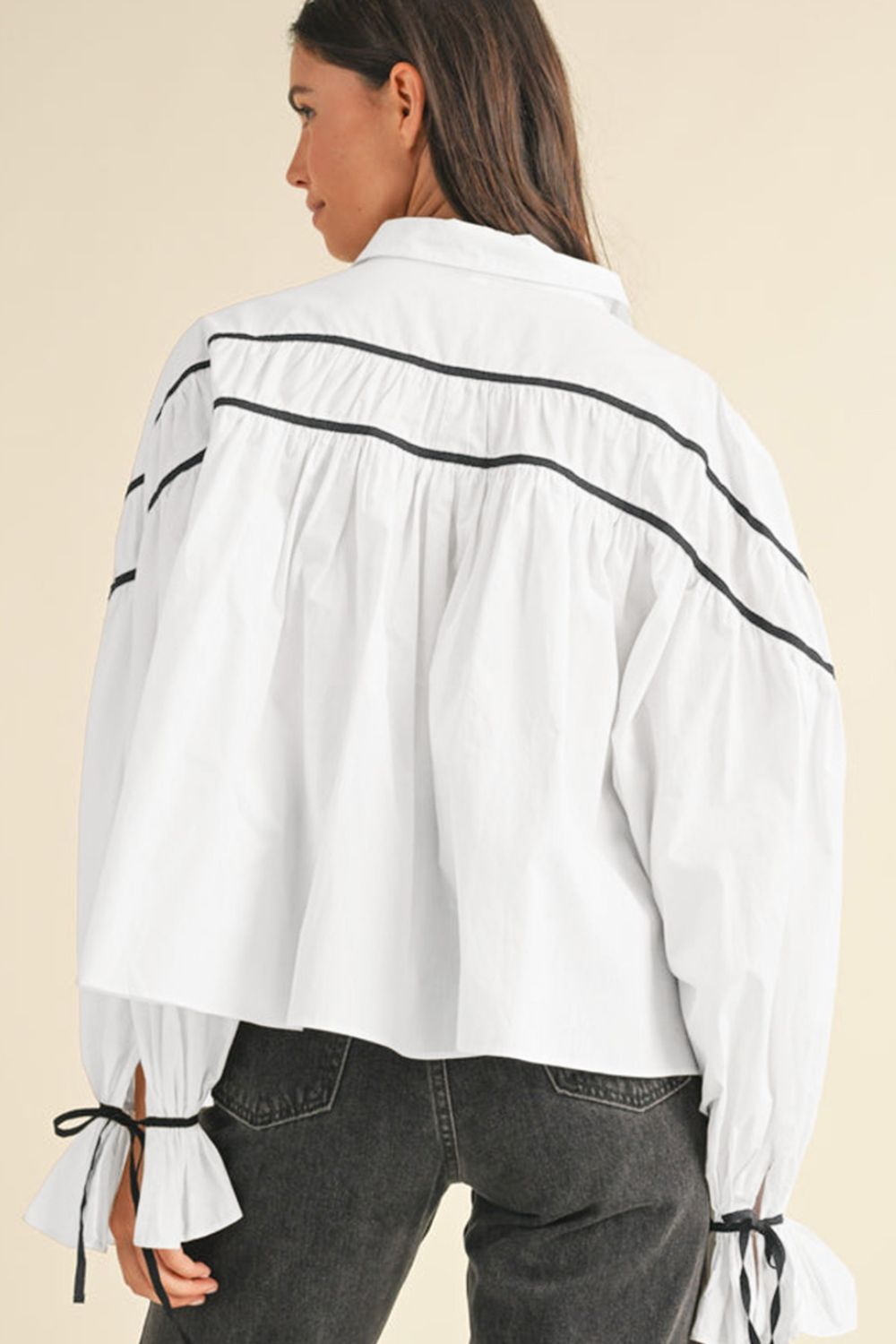 White piped trim blouse with gathered detail and bow tie cuffs.
