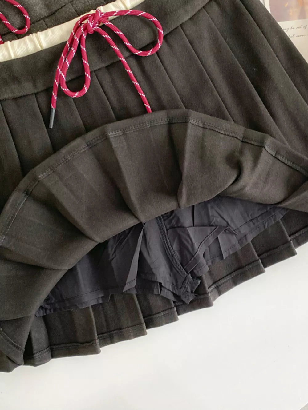 Dark gray pleated skirt with drawstring and built-in shorts.