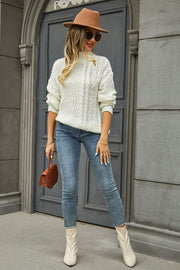 White cable-knit turtleneck sweater with voluminous silhouette and mock neck.