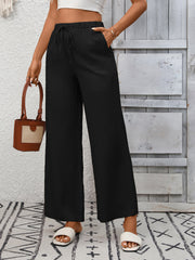 Black high-waist wide-leg pants with drawstring and pockets.