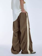 Brown relaxed fit sweatpants with cream side stripe and drawstring detail.