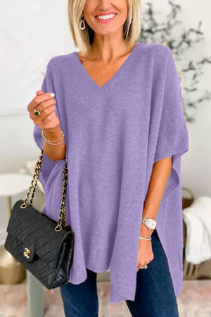 Relaxed lavender V-neck knit poncho top with side slits, styled with a black quilted handbag.