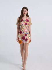 Embroidered floral mini dress with puff sleeves in a sheer nude fabric with colorful applique flowers.