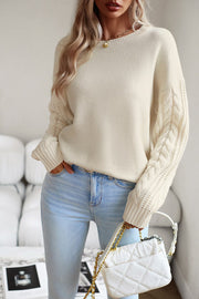 Cream cable-knit sleeve relaxed fit sweater with crew neck and ribbed cuffs.