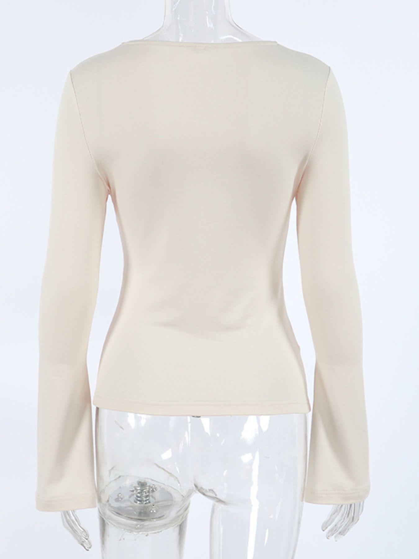 Beige long-sleeve shirt with knot front and cutout detail.