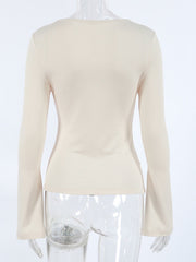 Beige long-sleeve shirt with knot front and cutout detail.