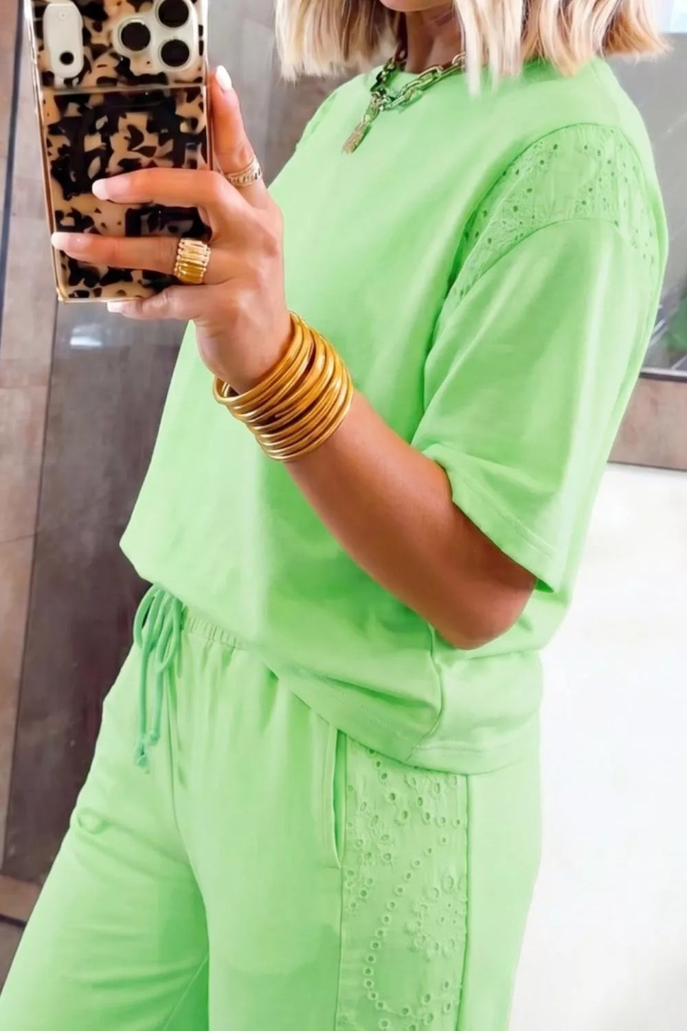 Lime green cotton two-piece set with embroidered eyelet details on sleeves and pants, drawstring waist.