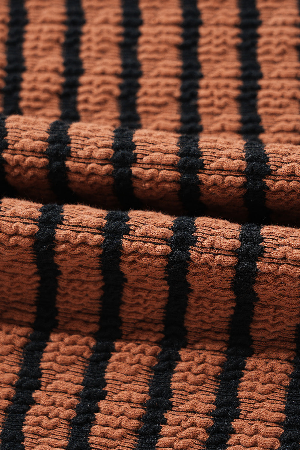 Textured henley knit top in caramel with black stripes and a textured fabric detail.