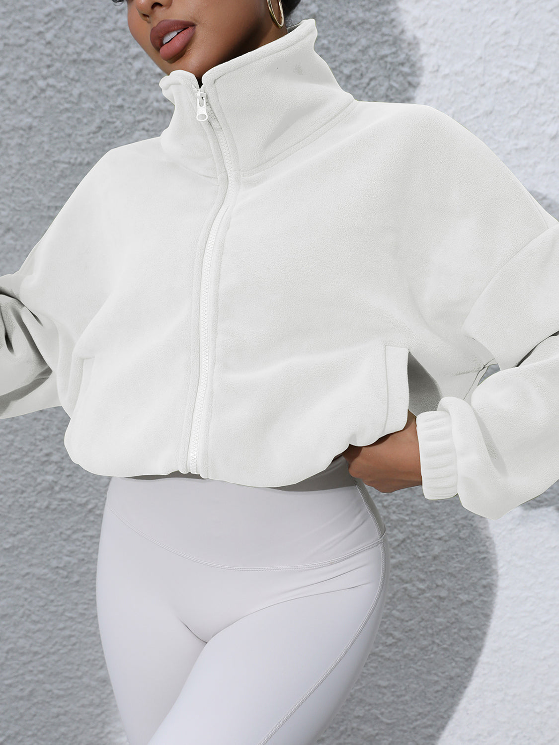 White fleece cropped funnel neck jacket with zip front and pockets.