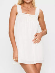 White frilled square neck mini dress with drawstring tie and textured fabric.