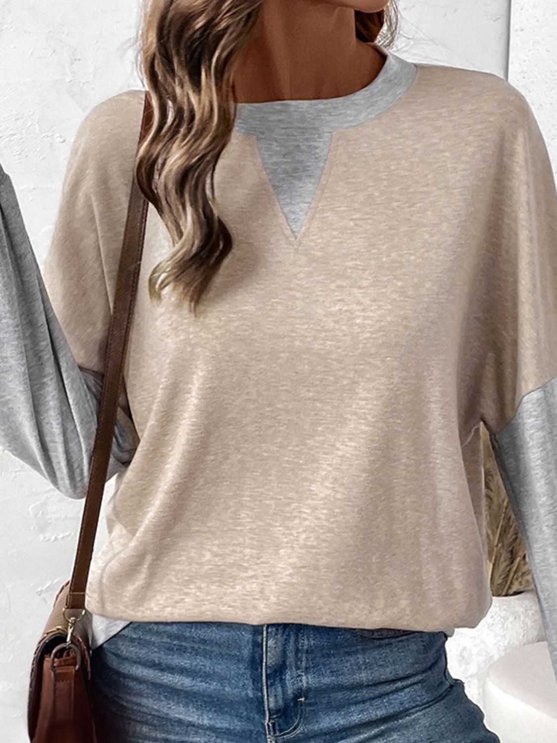 Tan and grey colorblock sweatshirt with V-neck detail and long sleeves.
