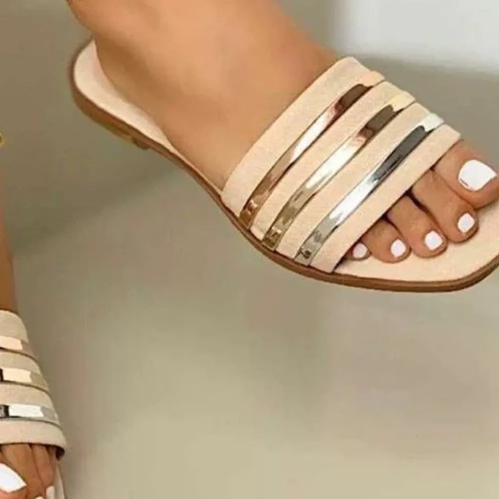 Beige open-toe flat sandals with metallic stripe detail across the vamp.