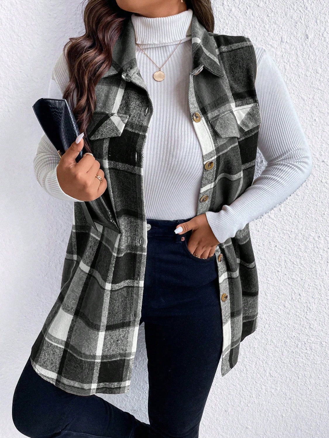 Oversized plaid shirt vest in black and white with button front and chest pockets.