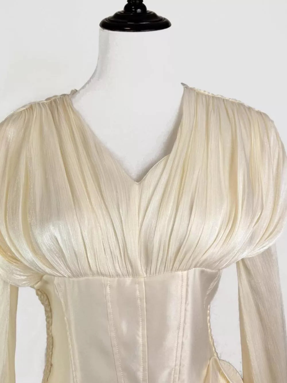 White cotton mini dress with corset waist and ruffled V-neck bodice.