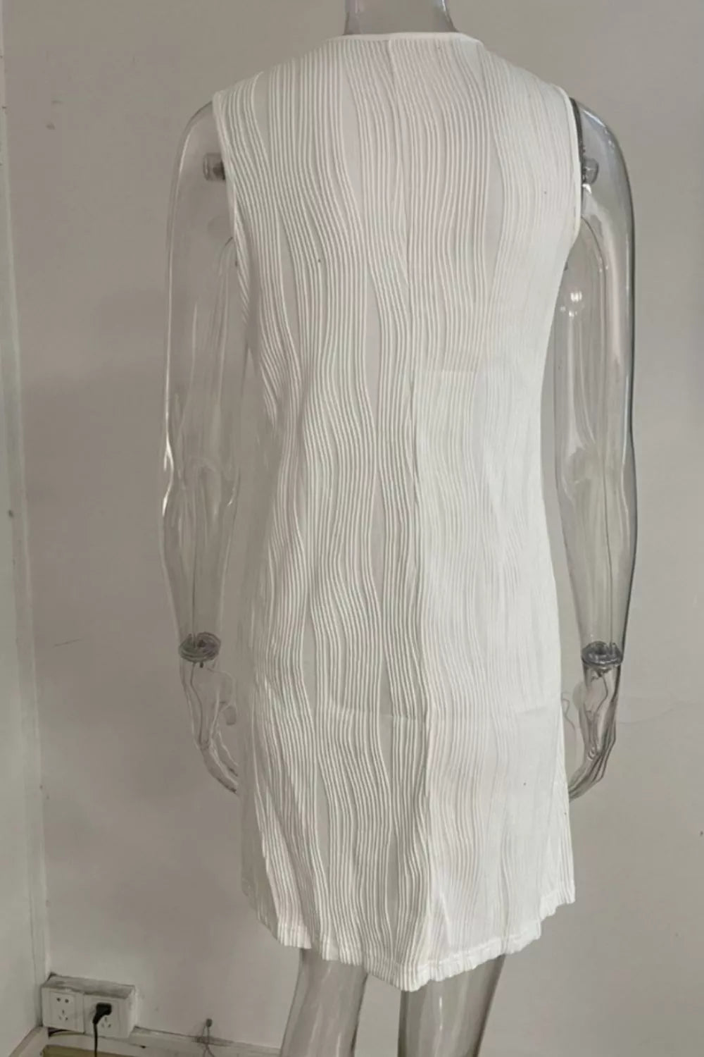 White textured mini dress with V-neck and ring straps, cotton blend fabric.