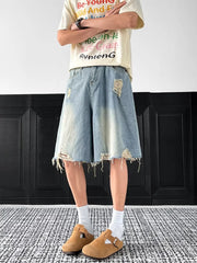 Light-wash denim shorts with distressed rips and frayed hem.
