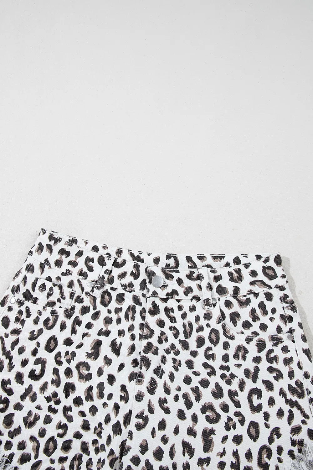Leopard print denim shorts with frayed hem and button fly.