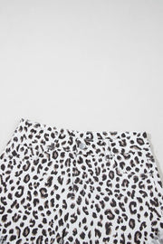 Leopard print denim shorts with frayed hem and button fly.