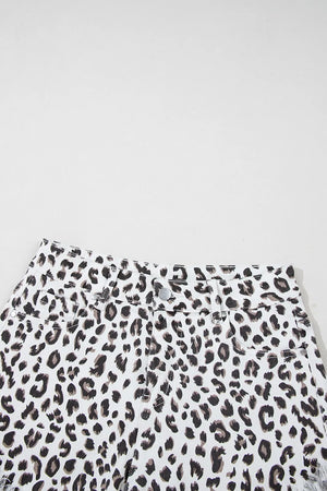 Leopard print denim shorts with frayed hem and button fly.