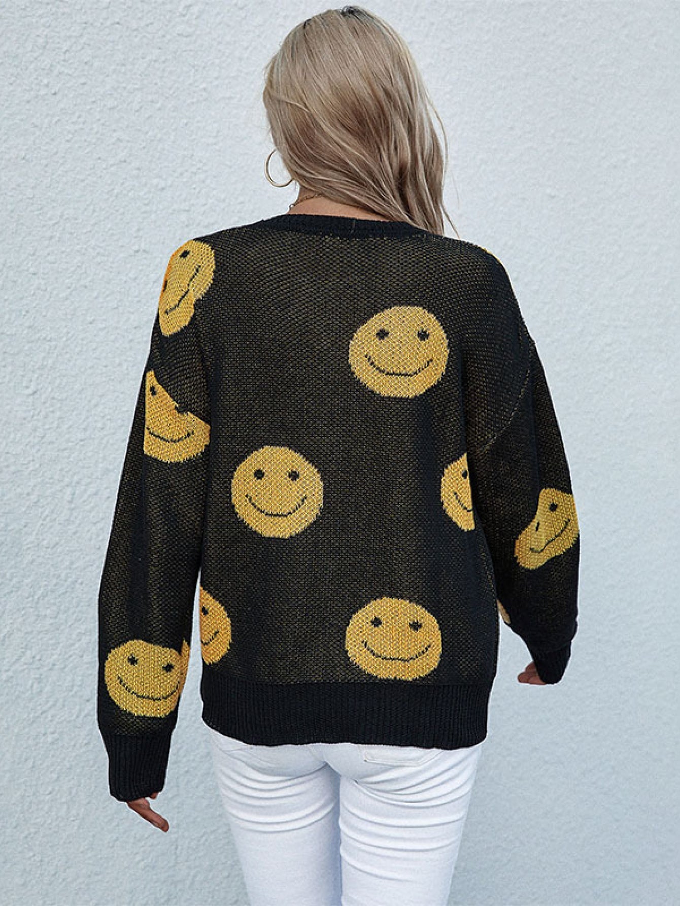 Black smiley face jacquard knit sweater with crewneck and long sleeves.