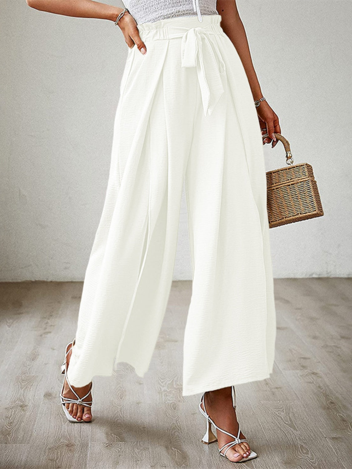 White pleated palazzo pants with sash and slit detail