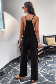Black relaxed drape pocket jumpsuit with spaghetti straps and wide legs.