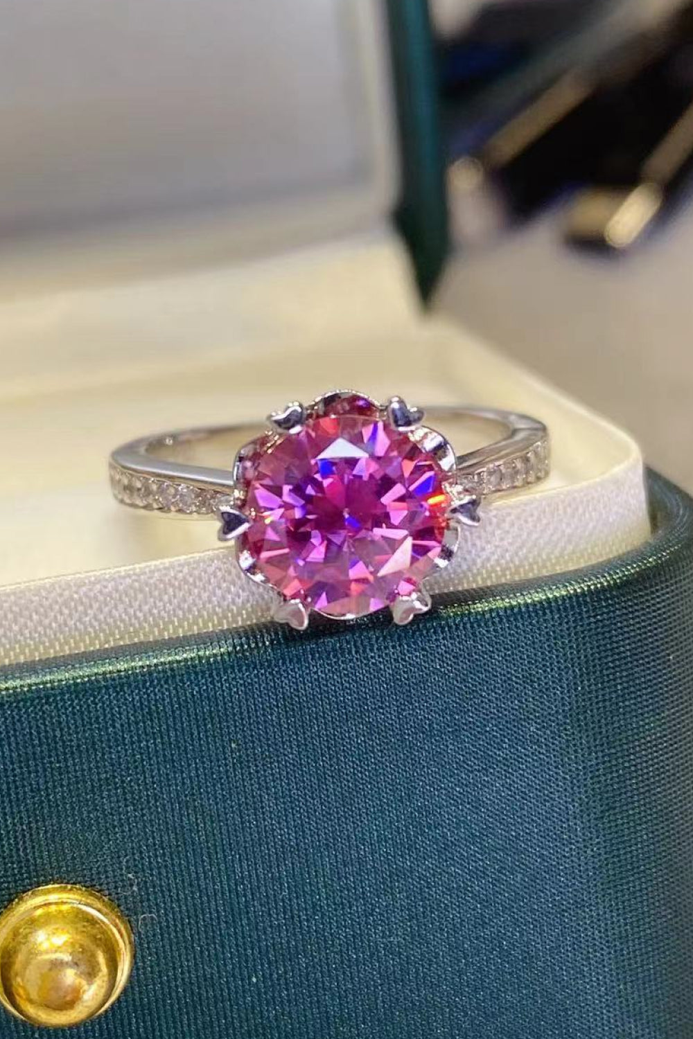 Pink moissanite and sterling silver ring with floral-inspired setting and pavé band.