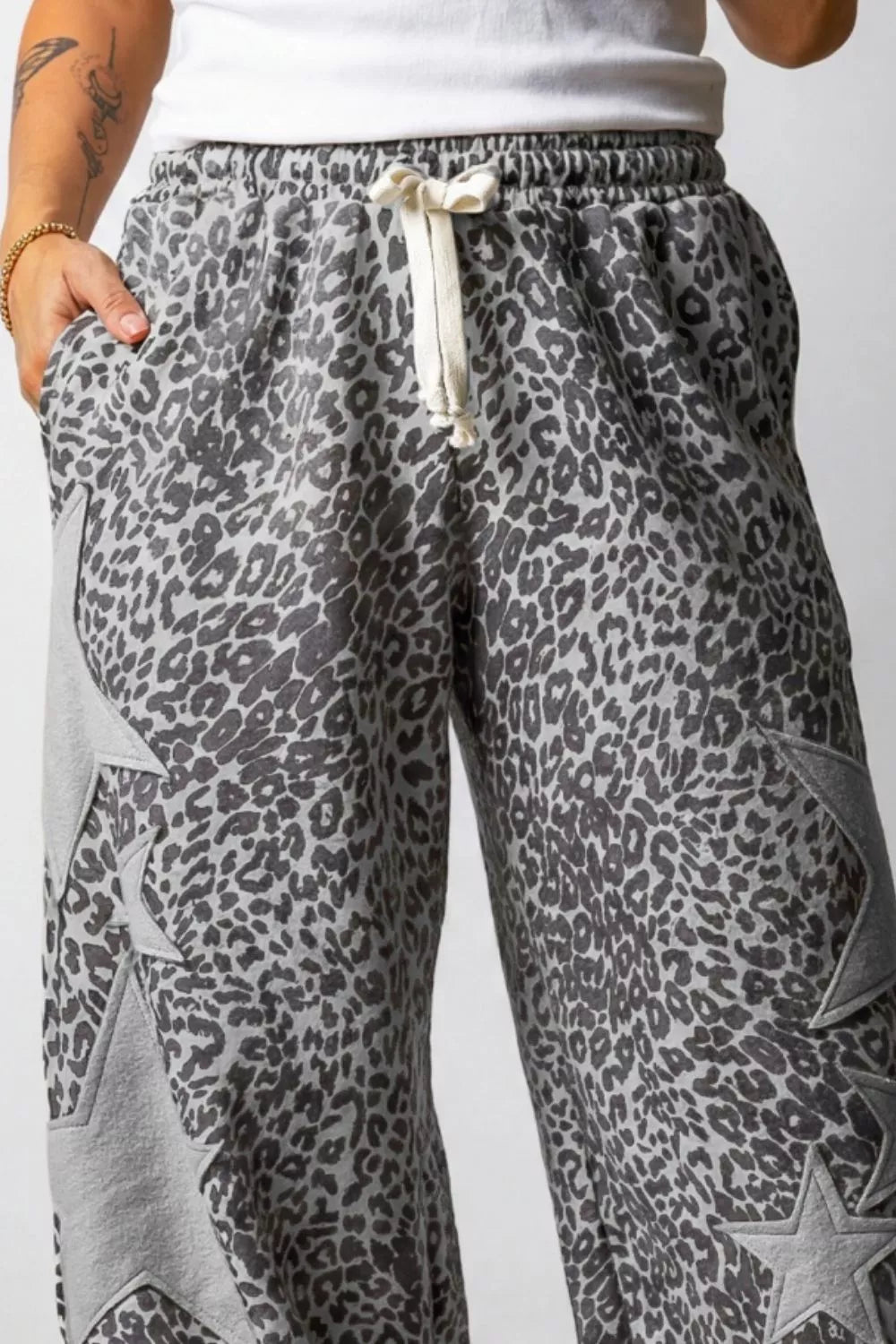 Leopard print wide-leg pants with star accents and drawstring waist.
