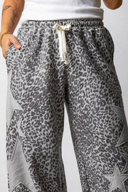 Leopard print wide-leg pants with star accents and drawstring waist.