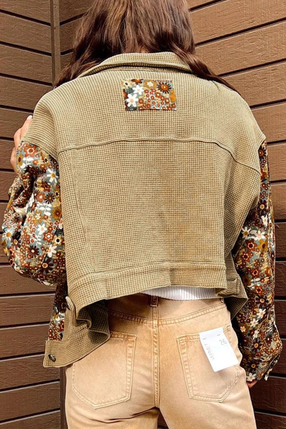Khaki waffle knit jacket with floral print sleeves and back panel detail.