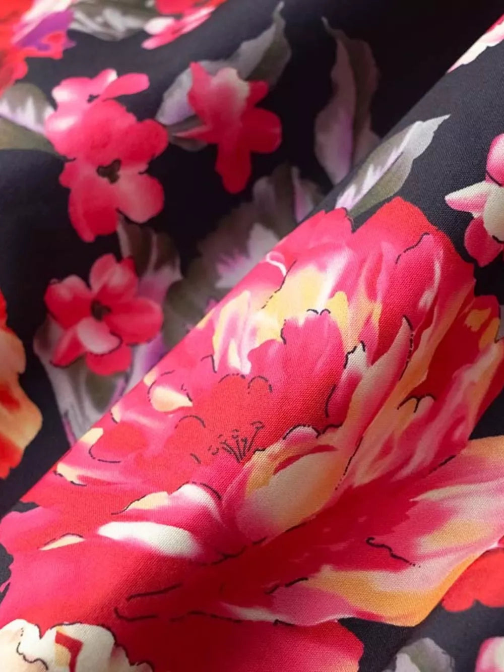 Black mini dress with vibrant floral print and ruffle hem detail