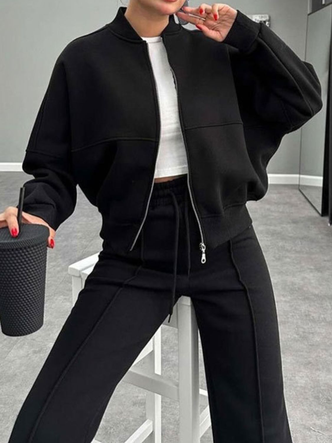 Black bomber jacket with zipper and wide-leg track pants with drawstring waist