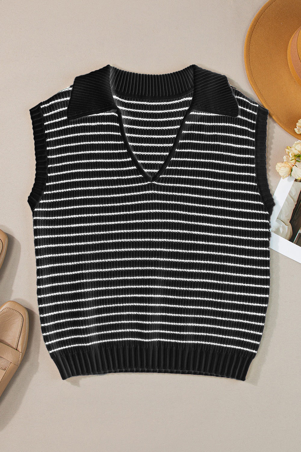 Black and ivory striped knit polo vest with a V-neck and collar.