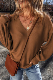 Brown ribbed knit pullover sweater with balloon sleeves and V-neck.