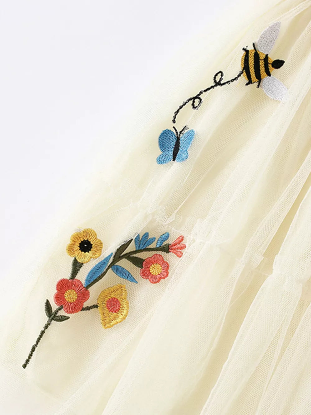 Cream tulle tiered toddler dress with embroidered bees, butterflies, and flowers.
