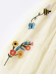 Cream tulle tiered toddler dress with embroidered bees, butterflies, and flowers.