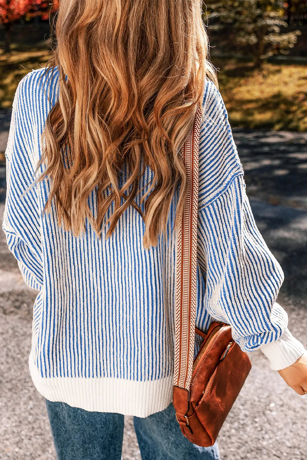 Light blue and white striped knit sweater with drop shoulders and a ribbed hem.