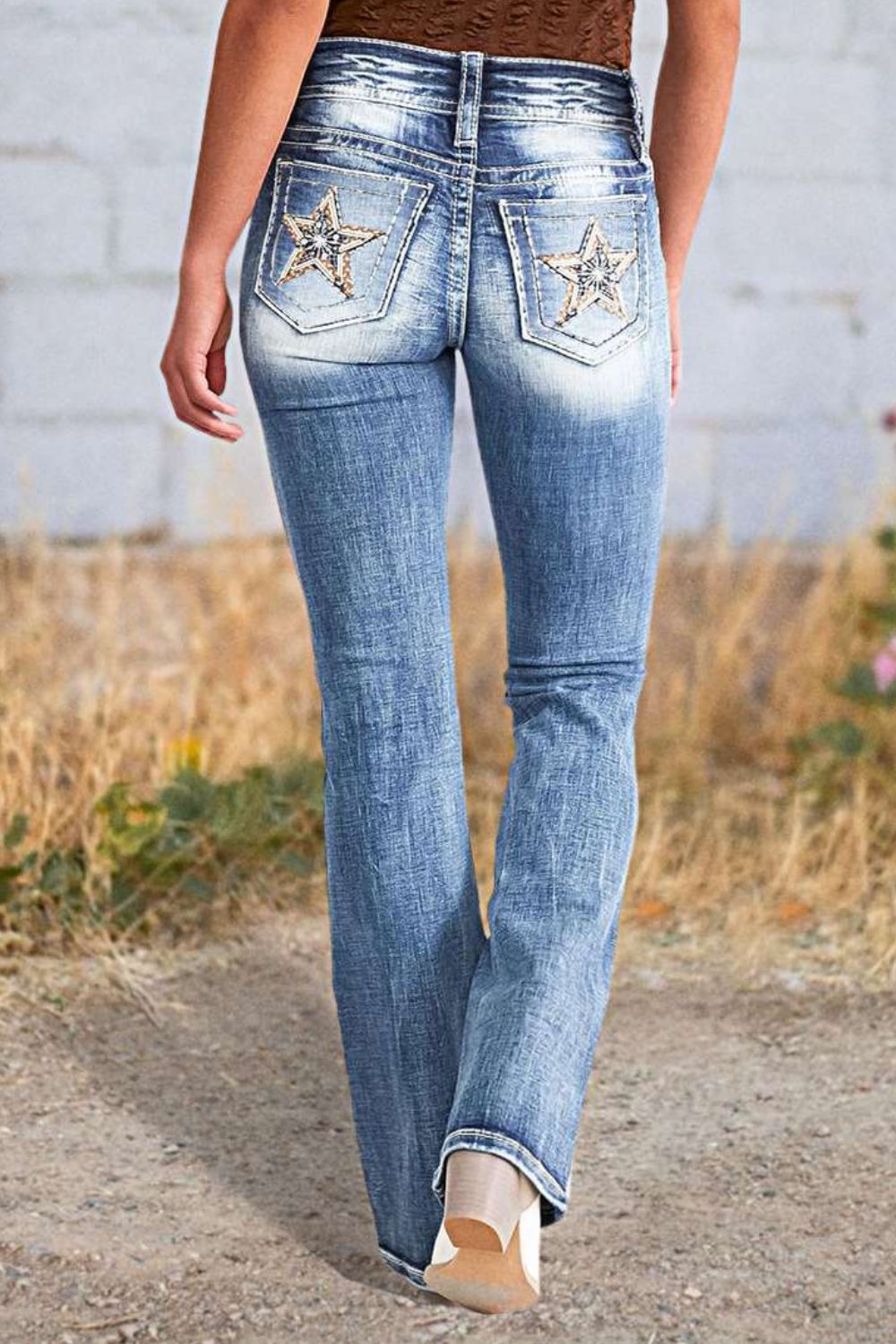 Light wash bootcut jeans with embroidered star back pockets.