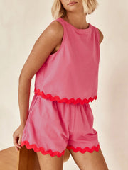 Fuchsia pink scalloped edge tank top and shorts set with red trim.