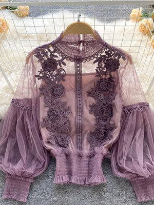 Purple lace blouse with floral embroidery and sheer puff sleeves, paired with a cami.