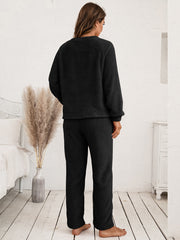 Black plush loungewear set with raglan sleeves and relaxed fit pants.