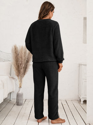 Black plush loungewear set with raglan sleeves and relaxed fit pants.