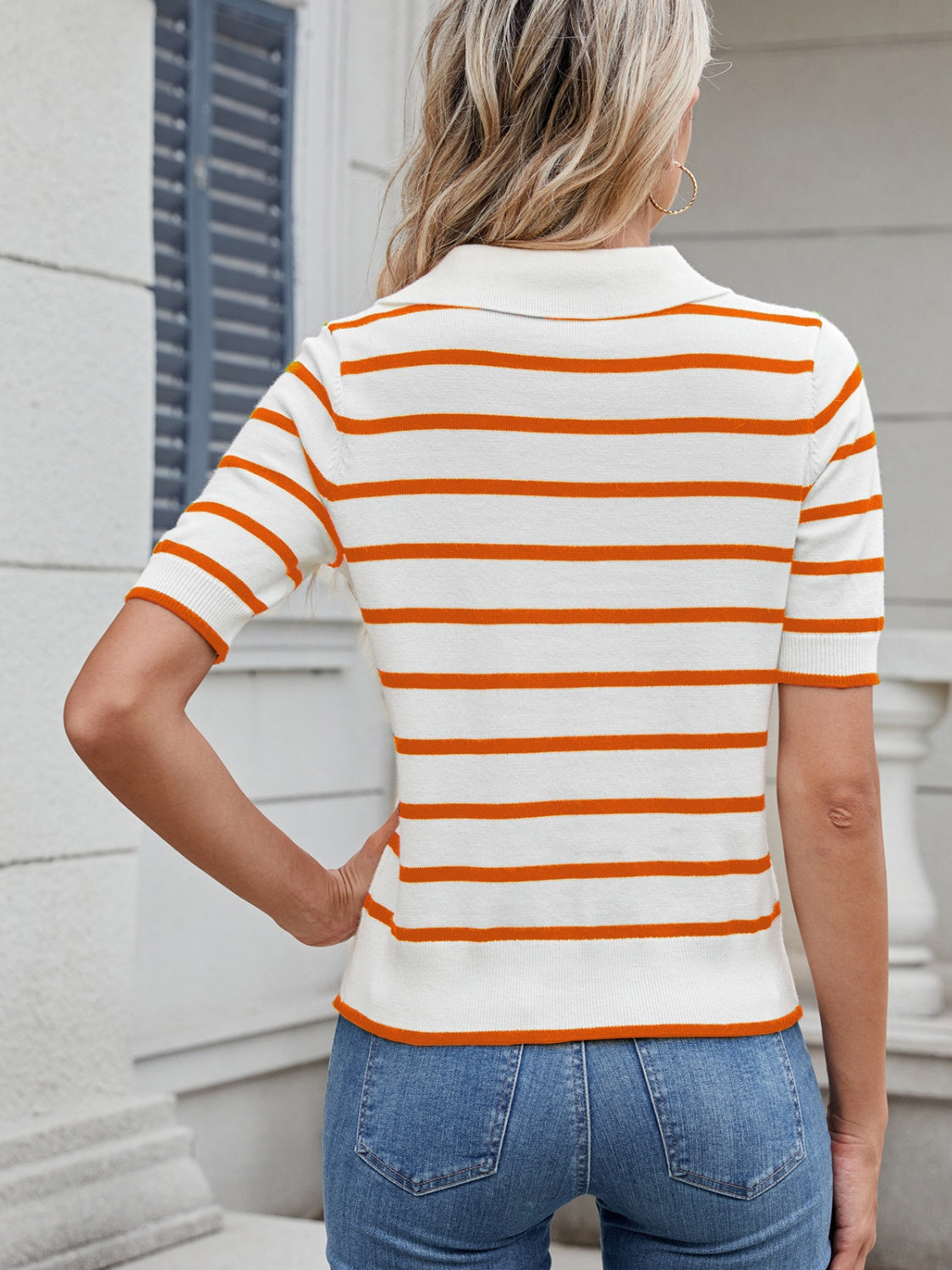 Orange and white striped knit polo top with short sleeves and collar.