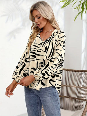 Women's abstract print blouson sleeve top in cream with black scribble pattern.